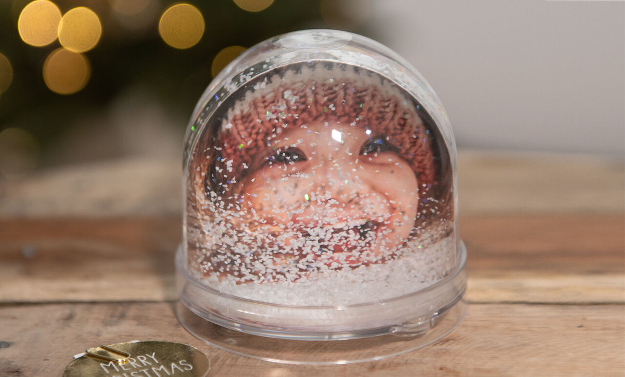 Boule à neige avec motif hivernal et décoration festive.