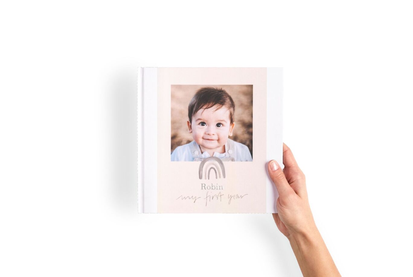 Livre photo format carré tenu entre les mains